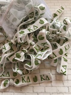 a pile of white and green ribbons on top of a brick floor next to a plastic bag