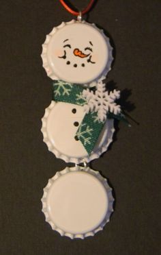 a bottle cap ornament with a snowman on it