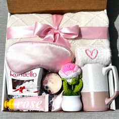 an open box containing items for a women's gift set including a mug, teddy bear and other personal care products