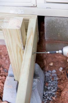 a person using a drill to fix a hole in the side of a building that is being built