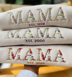 three embroidered pillows are stacked on top of each other in the shape of letters and numbers