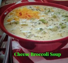 two red bowls filled with cheese broccoli soup on top of a checkered table cloth