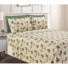 a bed with christmas themed sheets and pillows