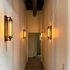 an empty hallway with two lights on either side