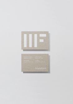 two business cards sitting on top of each other in front of a white wall with the word wif printed on it