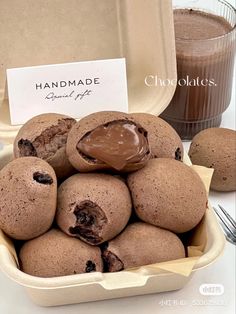 chocolate cookies are in a bowl next to a cup of coffee and a sign that says handmade