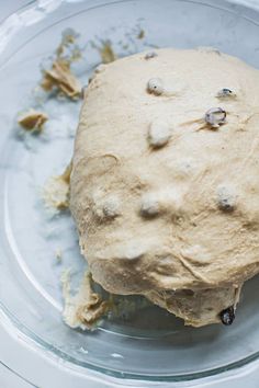 an uncooked dough sitting on top of a glass plate with crumbs