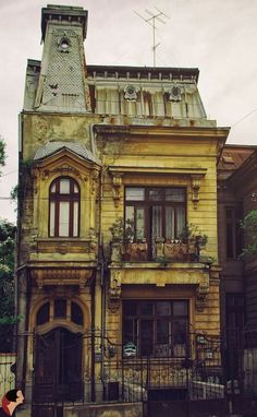 an old building with a clock tower on the top and balconies above it