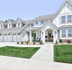 a large white house with lots of windows and grass on the front lawn in front of it