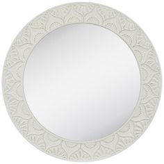 a white circular mirror with an intricate design on the front and back side, against a white background