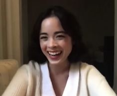 a woman is smiling and wearing a robe