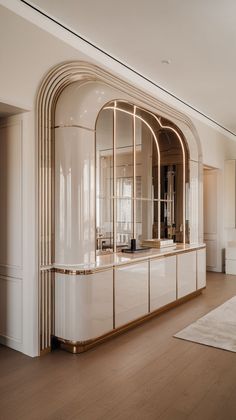 a large white kitchen with gold trimmings and an arched window in the center