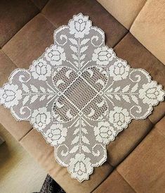 a white doily sitting on top of a brown couch