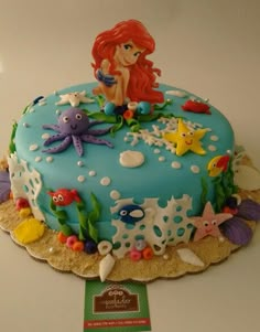 there is a cake decorated with an image of a little mermaid on top of it