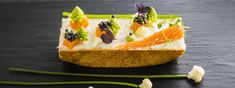 a piece of bread topped with fruit and veggies on top of a table