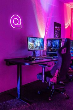 a desk with two computer monitors and a keyboard on it in front of a purple wall