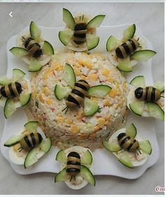 a plate topped with cucumber and cheese covered in sliced up bee's