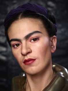 a woman with purple hair wearing a leather jacket and posing for a photo in front of a black background