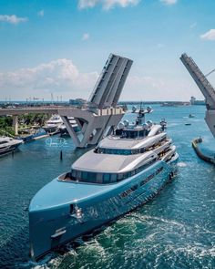 a large blue boat floating on top of the ocean next to a bridge over water