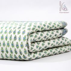 three folded sheets with blue and green flowers on them