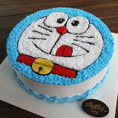 a cake decorated with blue icing and white frosting has a cartoon cat on it