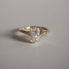 a close up of a diamond ring on a white surface with the top half cut off