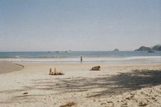 a man standing on top of a sandy beach next to the ocean