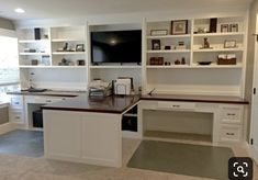 a home office with built - in shelving and desks