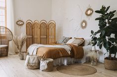 a bedroom with wicker furniture and plants in the corner, along with baskets on the floor