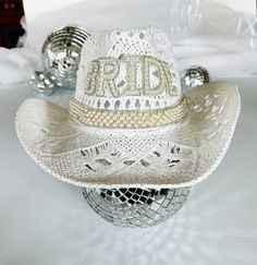 a white cowboy hat with the word rid on it sitting on top of a bed