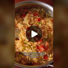 a pan filled with rice and vegetables on top of a table