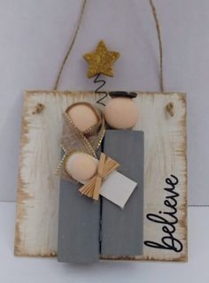 a wooden sign with two eggs and a star hanging from it's side on a wall