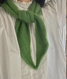 a woman wearing a green knitted scarf