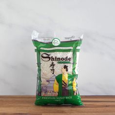 a bag of shinde rice sitting on top of a wooden table next to a white wall