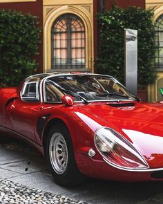 a red sports car parked in front of a building