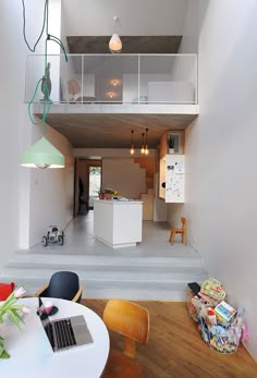 an open floor plan with stairs leading up to the upper level, and a kitchen in the background