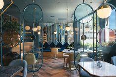 the interior of a restaurant with blue walls and round mirrors on the wall, along with wooden flooring