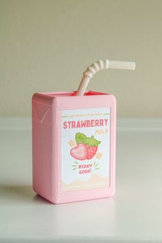 a pink box with a strawberries milk in it and a toothbrush sticking out of the top