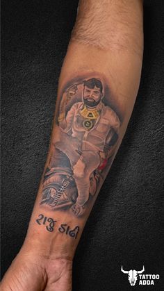 a man's arm with a tattoo on it that has a photo of a motorcycle rider