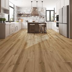 a large kitchen with white cabinets and wood flooring, along with an island in the middle