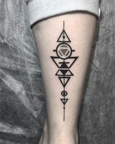 a black and white tattoo on the leg of a woman with geometric shapes in it