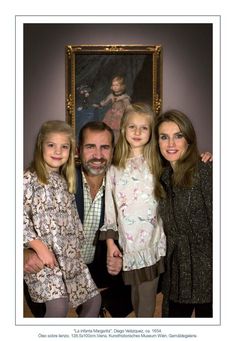 a family posing for a photo in front of a painting