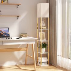 a desk with a computer on it in front of a window and bookshelf