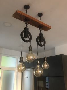 three light fixtures hanging from the ceiling in a kitchen