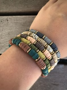 several different colored bracelets on someone's arm