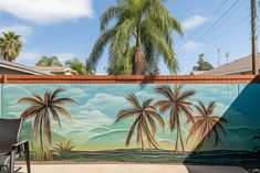 a mural on the side of a building with palm trees