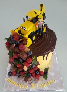 a birthday cake with a tractor and berries on top