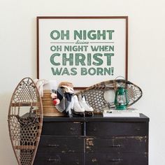 an old dresser with shoes and other items on it in front of a poster that reads oh night oh night when christ was born