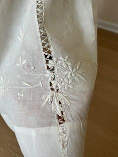 the back of a white dress with lace trimmings on it's sides