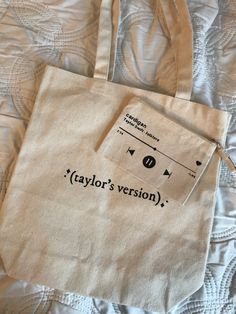 two bags sitting on top of a bed with the words taylor's version printed on them